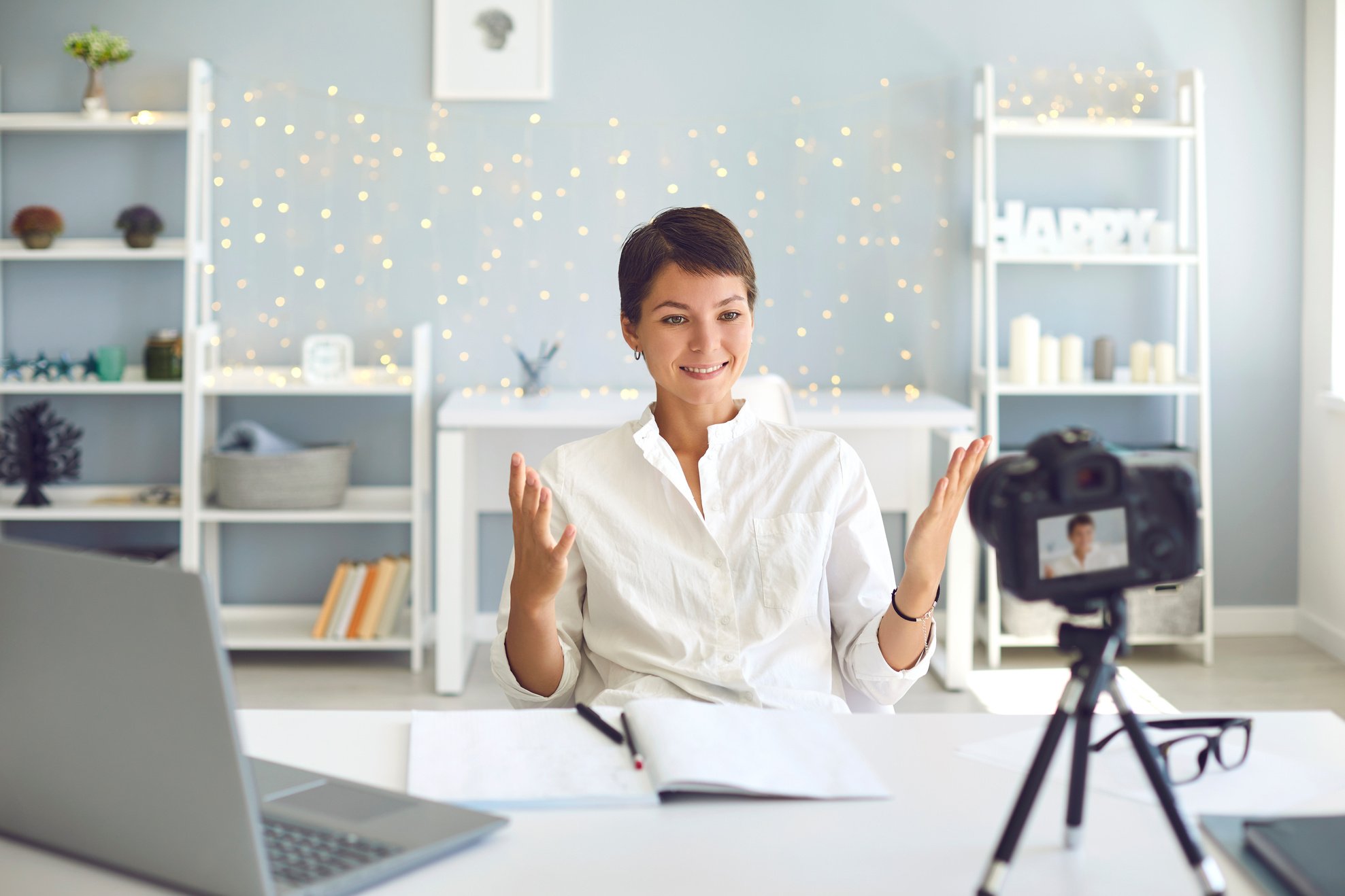 Cheerful Female Vlogger Recording a Video on Camera Sitting at Her Desk in Home Office